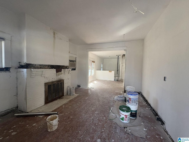 unfurnished living room with an AC wall unit and a fireplace