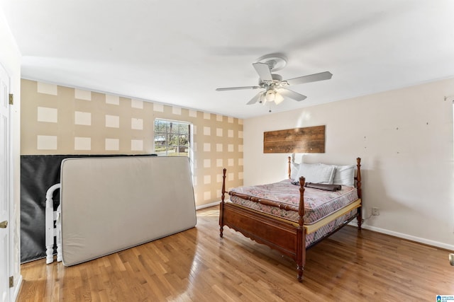 bedroom with light wood-type flooring, ceiling fan, and baseboards