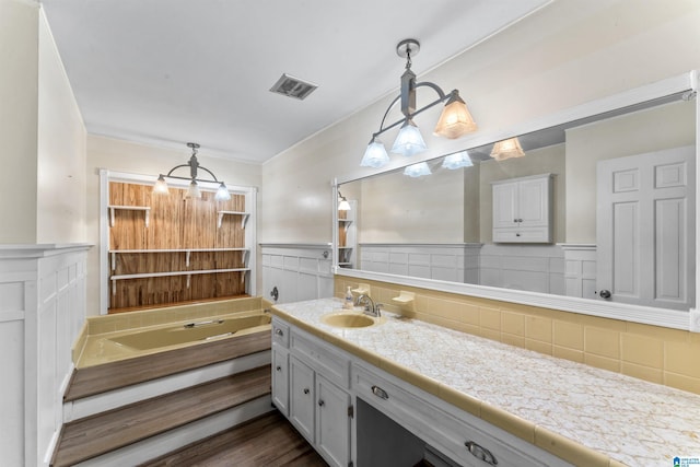 full bath with a bath, visible vents, wainscoting, and vanity