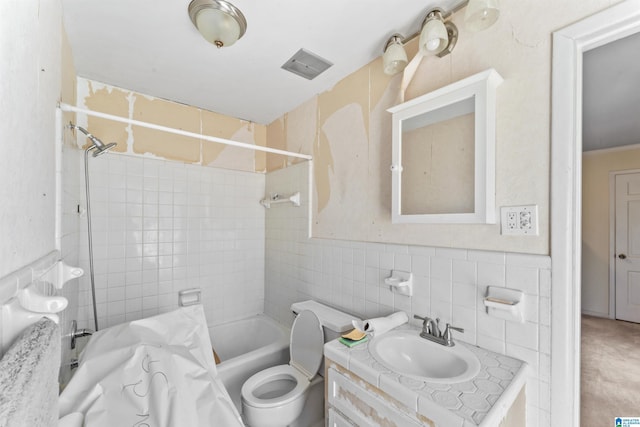 full bath featuring toilet, visible vents, vanity, tile walls, and shower / bathing tub combination