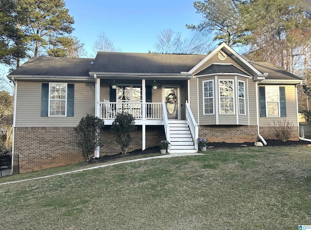 view of front of property featuring covered porch, a front lawn, and brick siding