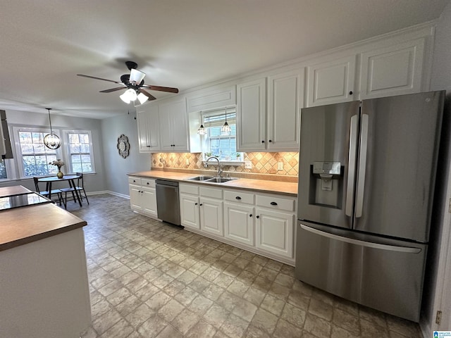 13733 Ginger Dr, Mccalla, AL 35111 - kitchen with a ceiling fan, stainless steel appliances, backsplash, a sink, and white cabinets