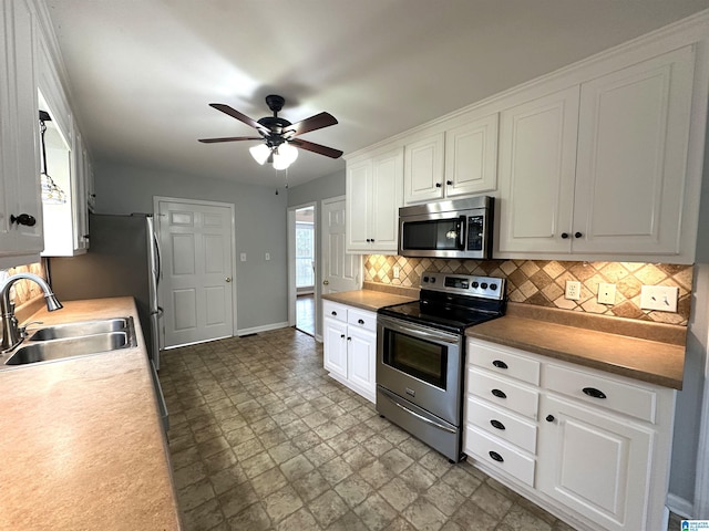 13733 Ginger Dr, Mccalla, AL 35111 - kitchen with a sink, white cabinetry, tasteful backsplash, appliances with stainless steel finishes, and ceiling fan