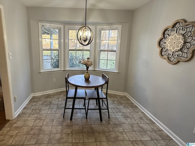 13733 Ginger Dr, Mccalla, AL 35111 - dining room with a notable chandelier, stone finish flooring, and baseboards