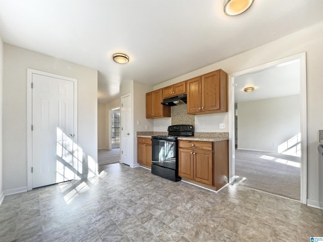 kitchen featuring under cabinet range hood, brown cabinets, black range with electric stovetop, and light countertops