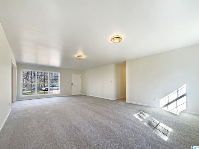 carpeted empty room featuring baseboards