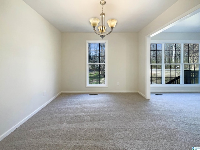 unfurnished room with baseboards, carpet flooring, and an inviting chandelier