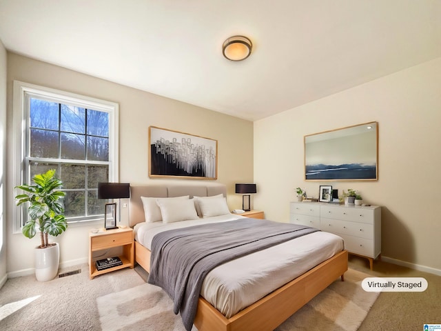 carpeted bedroom with visible vents and baseboards