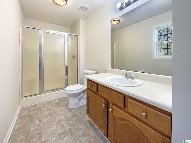 bathroom featuring toilet, vanity, visible vents, baseboards, and a stall shower