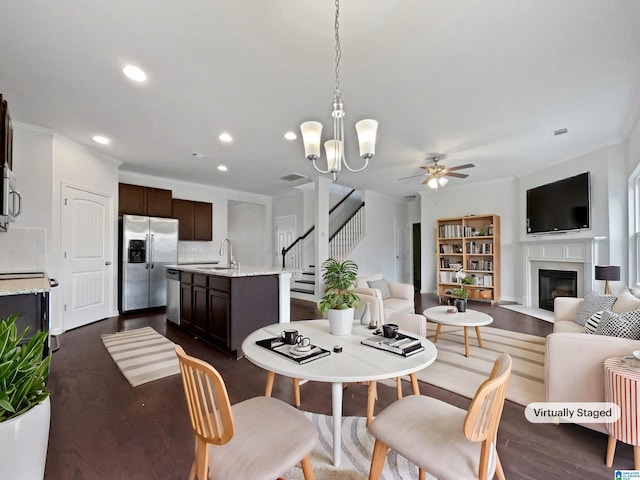 dining area featuring recessed lighting, dark wood finished floors, stairway, a glass covered fireplace, and crown molding