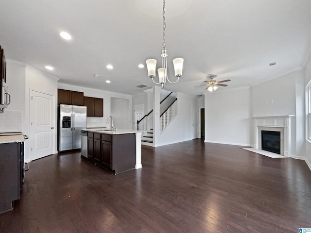 kitchen with dark wood-style flooring, a fireplace with flush hearth, open floor plan, dark brown cabinets, and appliances with stainless steel finishes