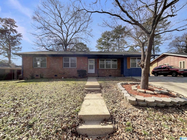 ranch-style home featuring a front yard, crawl space, brick siding, and driveway