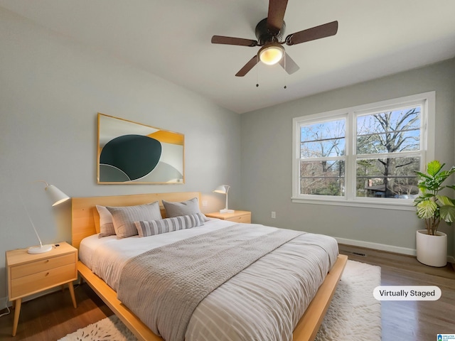 bedroom featuring wood finished floors, a ceiling fan, and baseboards