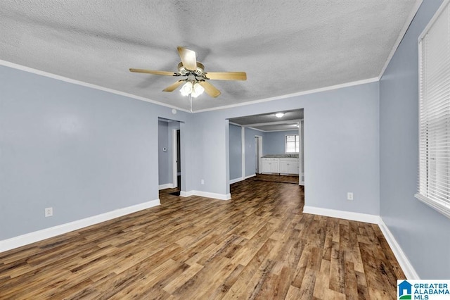 empty room featuring baseboards, wood finished floors, a ceiling fan, and crown molding