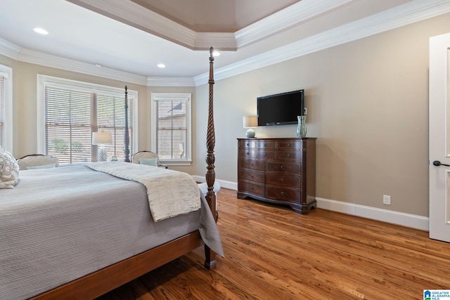 bedroom with multiple windows, baseboards, and wood finished floors