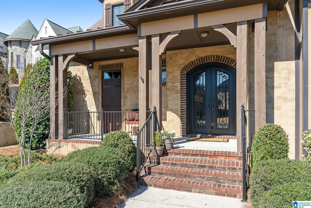 entrance to property featuring covered porch and french doors