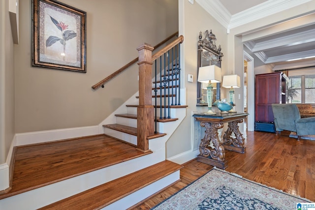 stairs with baseboards, wood finished floors, and crown molding