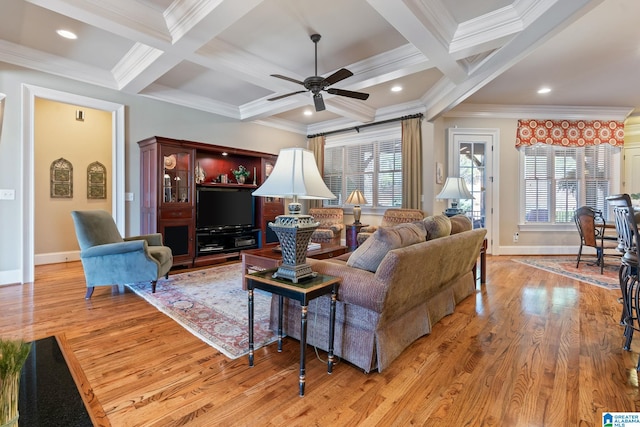 living room with a healthy amount of sunlight, beamed ceiling, and wood finished floors