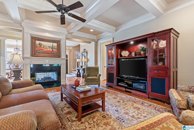 living area featuring beamed ceiling, coffered ceiling, wood finished floors, and a multi sided fireplace