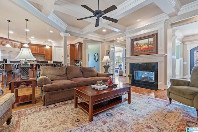 living area with a fireplace with flush hearth, coffered ceiling, beamed ceiling, and crown molding