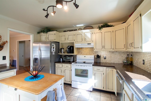 kitchen with light tile patterned flooring, under cabinet range hood, stainless steel appliances, ornamental molding, and tasteful backsplash