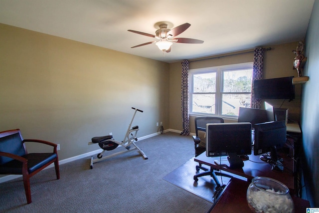 carpeted office space featuring baseboards and a ceiling fan