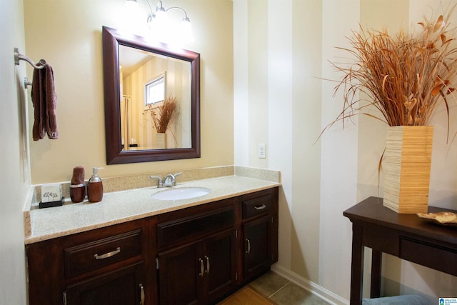 bathroom featuring tile patterned flooring, vanity, and baseboards