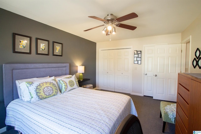 bedroom featuring baseboards, dark colored carpet, a ceiling fan, and multiple closets