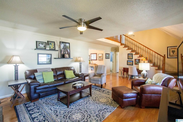 living room with ornamental molding, stairway, a textured ceiling, and wood finished floors