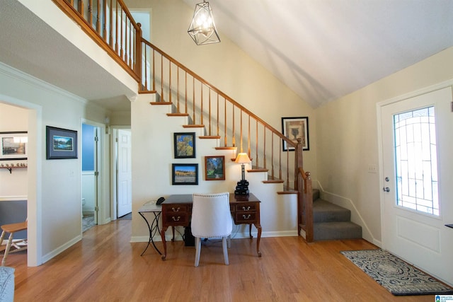 entryway featuring high vaulted ceiling, stairway, baseboards, and wood finished floors