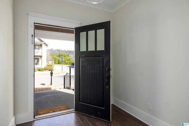 entryway with ornamental molding, baseboards, and wood finished floors