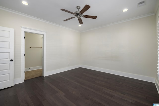 empty room with dark wood-type flooring, visible vents, and crown molding