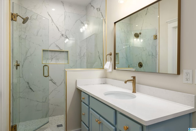 full bathroom featuring a marble finish shower and vanity