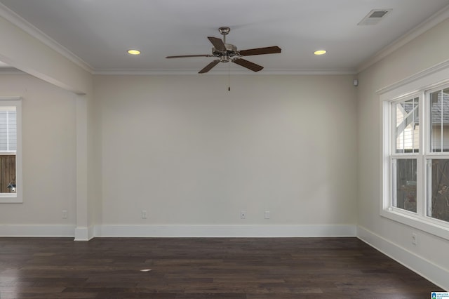 spare room featuring dark wood-style floors, baseboards, visible vents, and crown molding