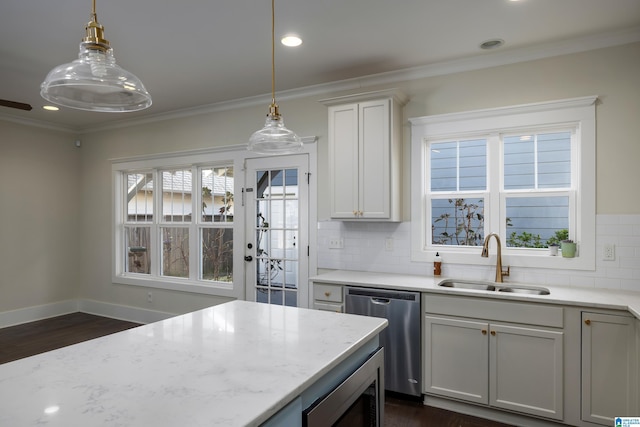 kitchen featuring crown molding, stainless steel appliances, a sink, and decorative light fixtures