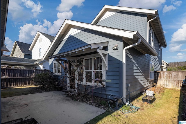 view of front of property featuring a patio area, fence, and a front lawn