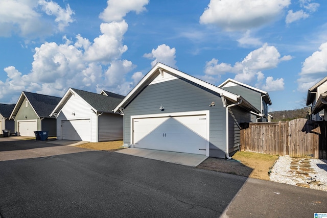 ranch-style home with a garage and fence