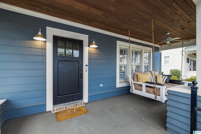 doorway to property featuring ceiling fan and a porch