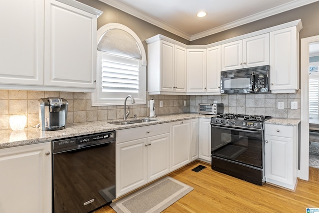 kitchen with crown molding, light wood-type flooring, black appliances, white cabinetry, and a sink