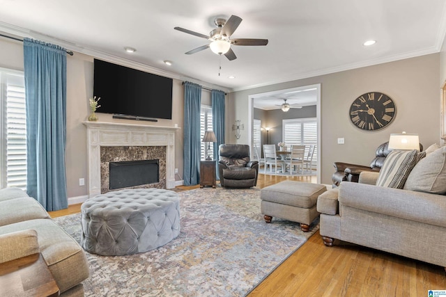 living area with plenty of natural light, ornamental molding, and wood finished floors