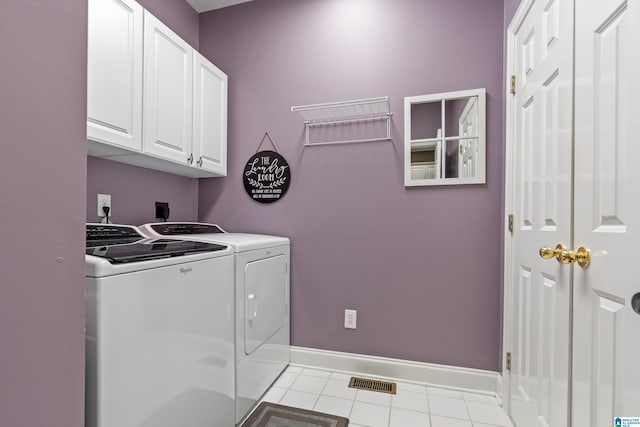 laundry area featuring tile patterned flooring, cabinet space, baseboards, and separate washer and dryer