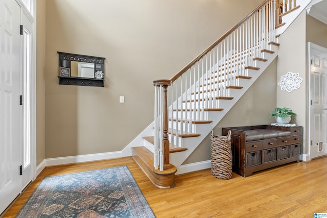 stairs with wood finished floors and baseboards