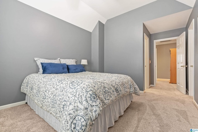 bedroom featuring light carpet, vaulted ceiling, visible vents, and baseboards