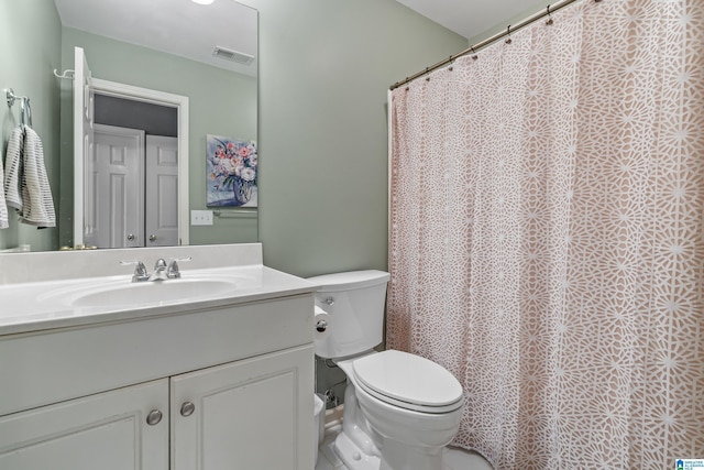 bathroom with toilet, curtained shower, vanity, and visible vents