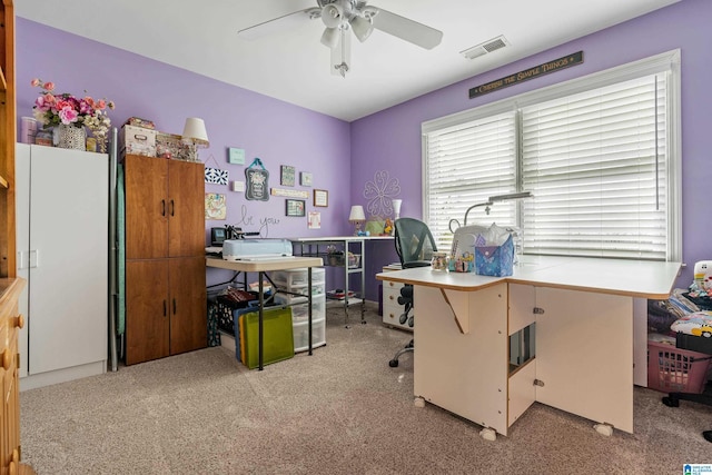 carpeted home office featuring a ceiling fan and visible vents