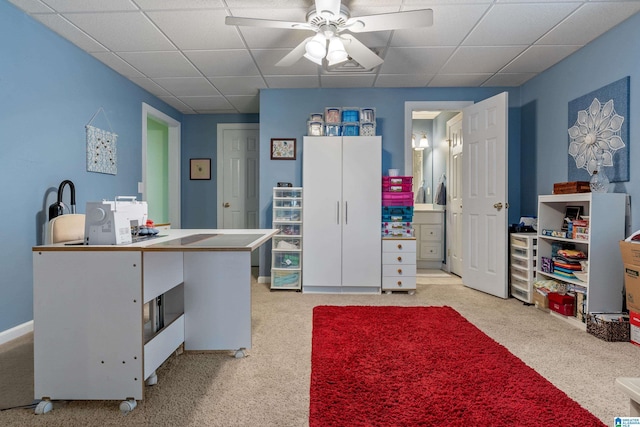 office featuring a paneled ceiling, ceiling fan, and light colored carpet