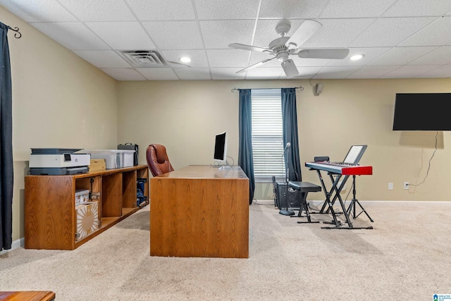 carpeted office space featuring a ceiling fan, visible vents, a drop ceiling, and baseboards