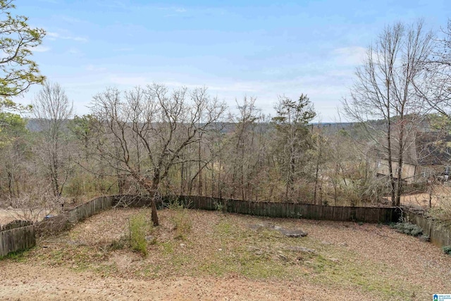 view of yard with a fenced backyard and a forest view