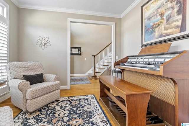 sitting room with light wood-style floors, baseboards, stairway, and ornamental molding