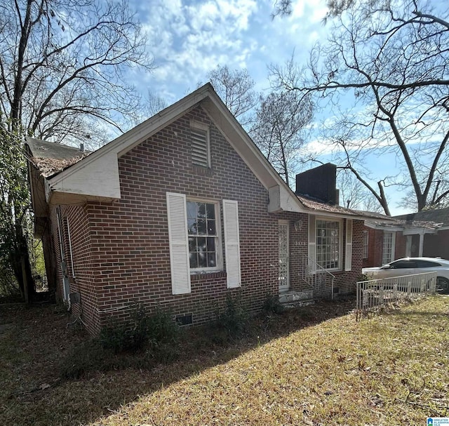 view of home's exterior with crawl space and brick siding